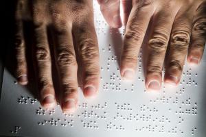 twee handen op een pagina met braille