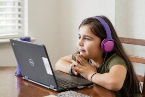 blind meisje luistert met koptelefoon en laptop